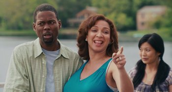 Movie still from “Grown Ups” (2010), directed by Dennis Dugan – A man and a woman standing next to each other near a body of water; Medium shot, Over the shoulder angle