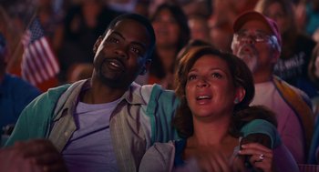 Movie still from “Grown Ups” (2010), directed by Dennis Dugan – A man and a woman are watching a show; Medium shot, Low angle