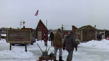 Movie still from “Grumpy Old Men” (1993), directed by Donald Petrie – A group of people walking in the snow near some buildings; Extreme Wide shot, Over the shoulder angle