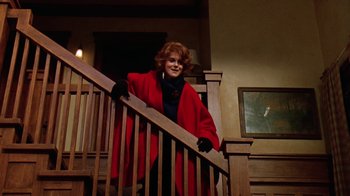 Movie still from “Grumpy Old Men” (1993), directed by Donald Petrie – A woman in a red coat standing at the top of the stairs; Medium shot, Low angle