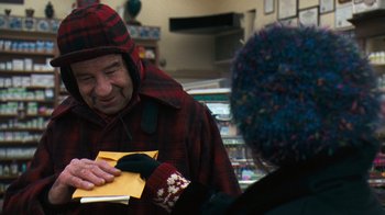 Movie still from “Grumpy Old Men” (1993), directed by Donald Petrie – An older man wearing a red and black jacket holding an envelope; Medium shot, Over the shoulder angle