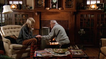 Movie still from “Grumpy Old Men” (1993), directed by Donald Petrie – An older man and a young woman sitting in front of a fireplace; Wide shot, High angle