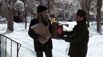 Movie still from “Grumpy Old Men” (1993), directed by Donald Petrie – A man giving a woman a bottle of soda and a bag of food; Medium shot, High angle