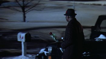 Movie still from “Grumpy Old Men” (1993), directed by Donald Petrie – A man in a suit and hat holding a red rose; Wide shot, Over the shoulder angle