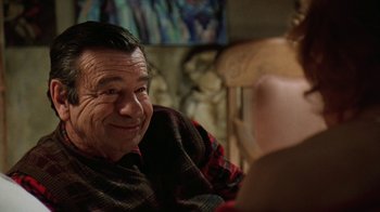 Movie still from “Grumpy Old Men” (1993), directed by Donald Petrie – An older man sitting at a table with a woman in the background; Close Up shot, Over the shoulder angle