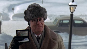 Movie still from “Grumpy Old Men” (1993), directed by Donald Petrie – An older man in a fur hat and glasses; Close Up shot, Over the shoulder angle