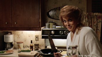 Movie still from “Grumpy Old Men” (1993), directed by Donald Petrie – A woman holding a knife in a pan in a kitchen; Close Up shot, Low angle
