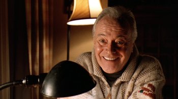 Movie still from “Grumpy Old Men” (1993), directed by Donald Petrie – An older man smiling for the camera with a lamp in front of him; Close Up shot, Low angle