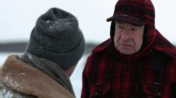 Movie still from “Grumpy Old Men” (1993), directed by Donald Petrie – A man wearing a hat and a plaid shirt talking to another man wearing a hat; Close Up shot, Over the shoulder angle