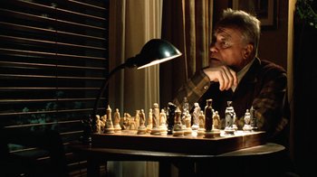 Movie still from “Grumpy Old Men” (1993), directed by Donald Petrie – A man sitting in front of a chess board; Close Up shot, High angle