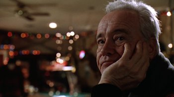 Movie still from “Grumpy Old Men” (1993), directed by Donald Petrie – An older man with white hair is sitting with his hand under his chin; Close Up shot, Low angle