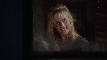 Movie still from “Grumpy Old Men” (1993), directed by Donald Petrie – A woman smiles while looking into a mirror; Close Up shot, Over the shoulder angle
