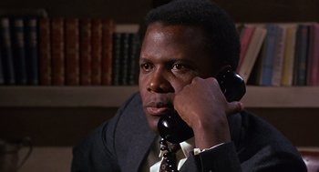 Movie still from “Guess Who's Coming to Dinner” (1967), directed by Stanley Kramer – A man talking on a phone while wearing a suit and tie; Close Up shot, Low angle