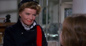 Movie still from “Guess Who's Coming to Dinner” (1967), directed by Stanley Kramer – An older woman wearing a black coat and a red hat; Close Up shot, Over the shoulder angle