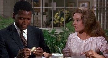 Movie still from “Guess Who's Coming to Dinner” (1967), directed by Stanley Kramer – A man and a woman sitting at a table with a sandwich; Medium shot, Over the shoulder angle