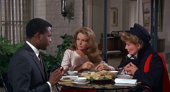 Movie still from “Guess Who's Coming to Dinner” (1967), directed by Stanley Kramer – A group of people sitting at a table eating food; Medium shot, Over the shoulder angle