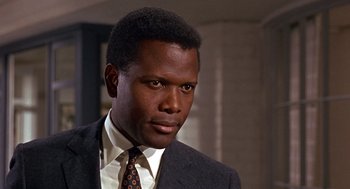 Movie still from “Guess Who's Coming to Dinner” (1967), directed by Stanley Kramer – A man in a suit and tie looking at the camera; Close Up shot, Low angle