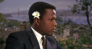 Movie still from “Guess Who's Coming to Dinner” (1967), directed by Stanley Kramer – A man in a suit with a flower in his hair; Close Up shot, Over the shoulder angle