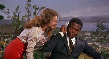 Movie still from “Guess Who's Coming to Dinner” (1967), directed by Stanley Kramer – A man in a suit and a woman in a dress; Medium shot, Over the shoulder angle