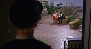 Movie still from “Guess Who's Coming to Dinner” (1967), directed by Stanley Kramer – A man and a woman sitting on a chair in front of a camera; Wide shot, Over the shoulder angle