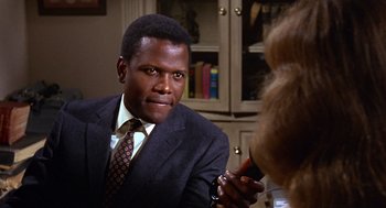 Movie still from “Guess Who's Coming to Dinner” (1967), directed by Stanley Kramer – A man wearing a suit and tie in a room; Close Up shot, Over the shoulder angle
