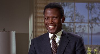 Movie still from “Guess Who's Coming to Dinner” (1967), directed by Stanley Kramer – A man wearing a suit and tie smiling for the camera; Close Up shot, Low angle