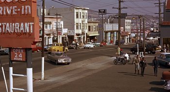 Movie still from “Guess Who's Coming to Dinner” (1967), directed by Stanley Kramer – An intersection in a city with cars parked on the side of the road; Extreme Wide shot, High angle