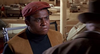 Movie still from “Guess Who's Coming to Dinner” (1967), directed by Stanley Kramer – A man wearing a red hat and a brown jacket; Close Up shot, Over the shoulder angle
