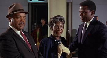 Movie still from “Guess Who's Coming to Dinner” (1967), directed by Stanley Kramer – A group of people standing next to each other in a room; Medium shot, Low angle