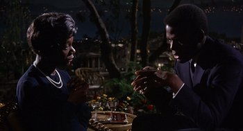 Movie still from “Guess Who's Coming to Dinner” (1967), directed by Stanley Kramer – A man and a woman sitting at an outdoor table; Medium shot, High angle