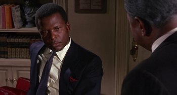 Movie still from “Guess Who's Coming to Dinner” (1967), directed by Stanley Kramer – A man wearing a suit and tie standing next to another man; Close Up shot, Over the shoulder angle