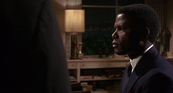 Movie still from “Guess Who's Coming to Dinner” (1967), directed by Stanley Kramer – A man in a suit and tie looking into the distance; Close Up shot, Over the shoulder angle