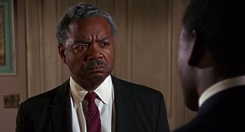 Movie still from “Guess Who's Coming to Dinner” (1967), directed by Stanley Kramer – An older black man in a suit and tie; Close Up shot, Over the shoulder angle