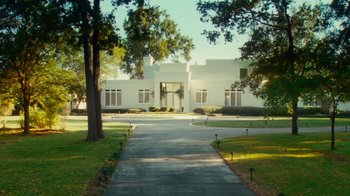 Movie still from “Trespass” (2011), directed by Joel Schumacher – A large white building sitting in the middle of a yard; Extreme Wide shot, Low angle