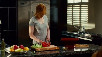 Movie still from “Trespass” (2011), directed by Joel Schumacher – A woman cutting a bell pepper on top of a cutting board in a kitchen; Medium shot, High angle