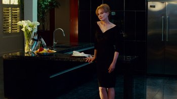Movie still from “Trespass” (2011), directed by Joel Schumacher – A woman in a black dress standing in front of a sink; Medium shot, Over the shoulder angle