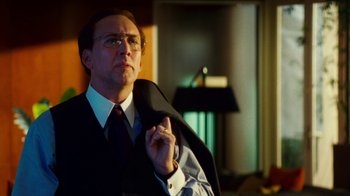 Movie still from “Trespass” (2011), directed by Joel Schumacher – A man in a suit and tie holding a suit jacket; Close Up shot, Low angle
