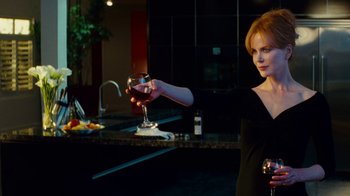 Movie still from “Trespass” (2011), directed by Joel Schumacher – A woman holding a glass of wine in her hand; Medium shot, Over the shoulder angle