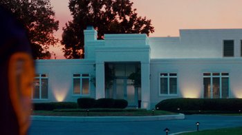 Movie still from “Trespass” (2011), directed by Joel Schumacher – A white building with trees in front of it; Extreme Wide shot, Low angle