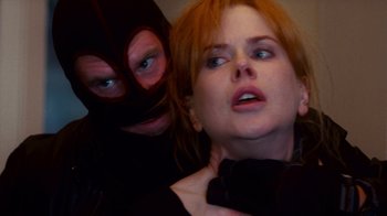 Movie still from “Trespass” (2011), directed by Joel Schumacher – A man and a woman in a black mask; Close Up shot, Over the shoulder angle