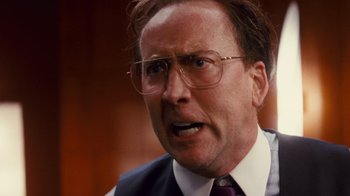 Movie still from “Trespass” (2011), directed by Joel Schumacher – An older man in a suit and glasses; Close Up shot, Over the shoulder angle