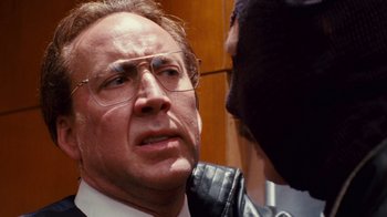 Movie still from “Trespass” (2011), directed by Joel Schumacher – A man in a suit and glasses talking to another man in a leather jacket; Close Up shot, Over the shoulder angle