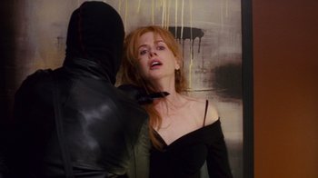 Movie still from “Trespass” (2011), directed by Joel Schumacher – A red headed woman in a black dress and a man in a black leather jacket; Close Up shot, Over the shoulder angle