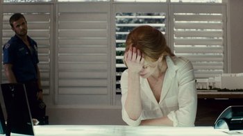 Movie still from “Trespass” (2011), directed by Joel Schumacher – A woman sitting at a table with her head in her hand; Medium shot, Over the shoulder angle
