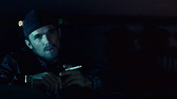 Movie still from “Trespass” (2011), directed by Joel Schumacher – A man holding a lit cigarette in his hand; Close Up shot, Low angle
