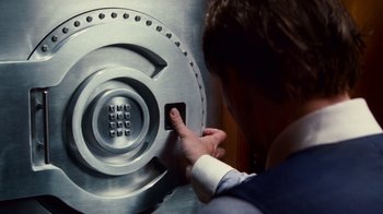 Movie still from “Trespass” (2011), directed by Joel Schumacher – A man in a white shirt and blue tie is by a silver door; Extreme Close Up shot, Overhead angle