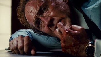 Movie still from “Trespass” (2011), directed by Joel Schumacher – A man with glasses is laying on the ground; Close Up shot, Low angle