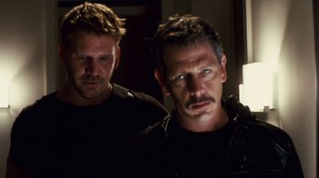 Movie still from “Trespass” (2011), directed by Joel Schumacher – Two men standing next to each other in the dark; Close Up shot, Over the shoulder angle
