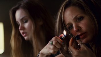 Movie still from “Trespass” (2011), directed by Joel Schumacher – A woman is lighting a cigarette in front of a mirror; Close Up shot, High angle
