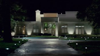 Movie still from “Trespass” (2011), directed by Joel Schumacher – A driveway leading to a large white building at night; Extreme Wide shot, Low angle